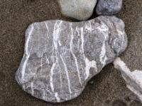 Graubrauner Stein durchzogen von vielen weißen Adern